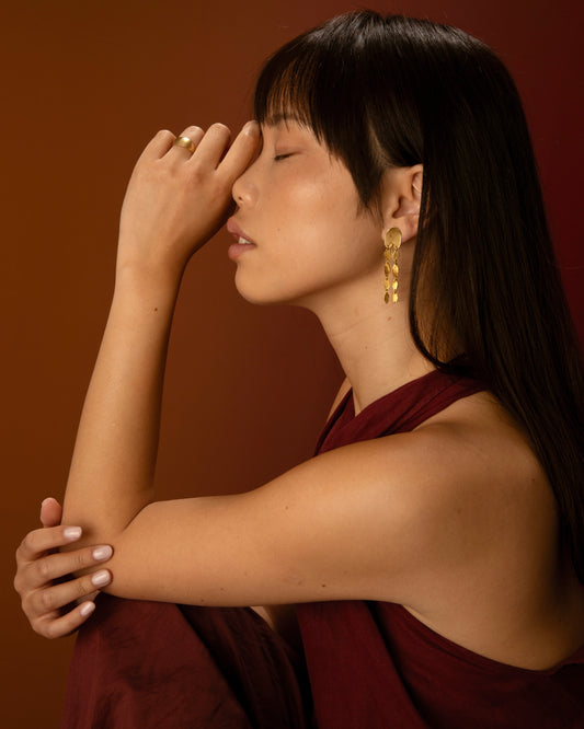 Anillo abombado de plata 925 bañado en oro 18k y pendientes largos. Foto modelo.