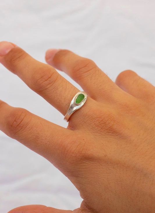 Anillo hecho a mano con cristal verde claro clavado, en plata. Foto modelo.