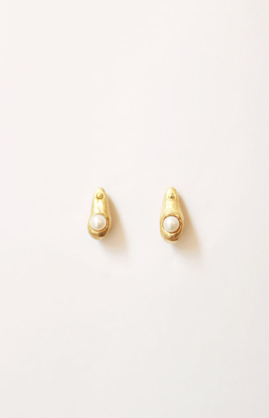 Pendientes artesanales en forma de gota con una perla cultivada incrustada, bañados en oro. Foto detalle.