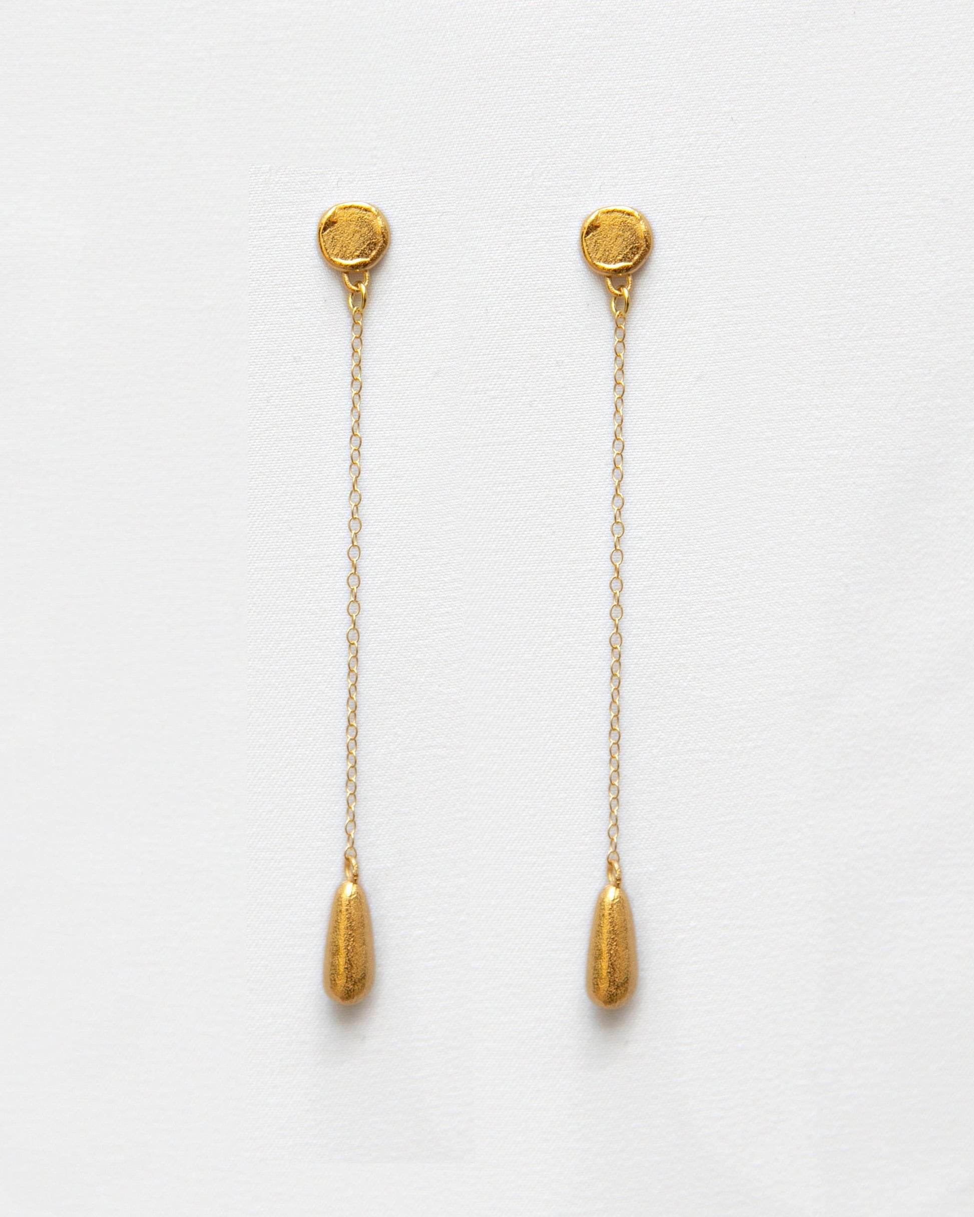 Pendientes bañados en oro en forma de lágrima con cadena. Foto detalle.