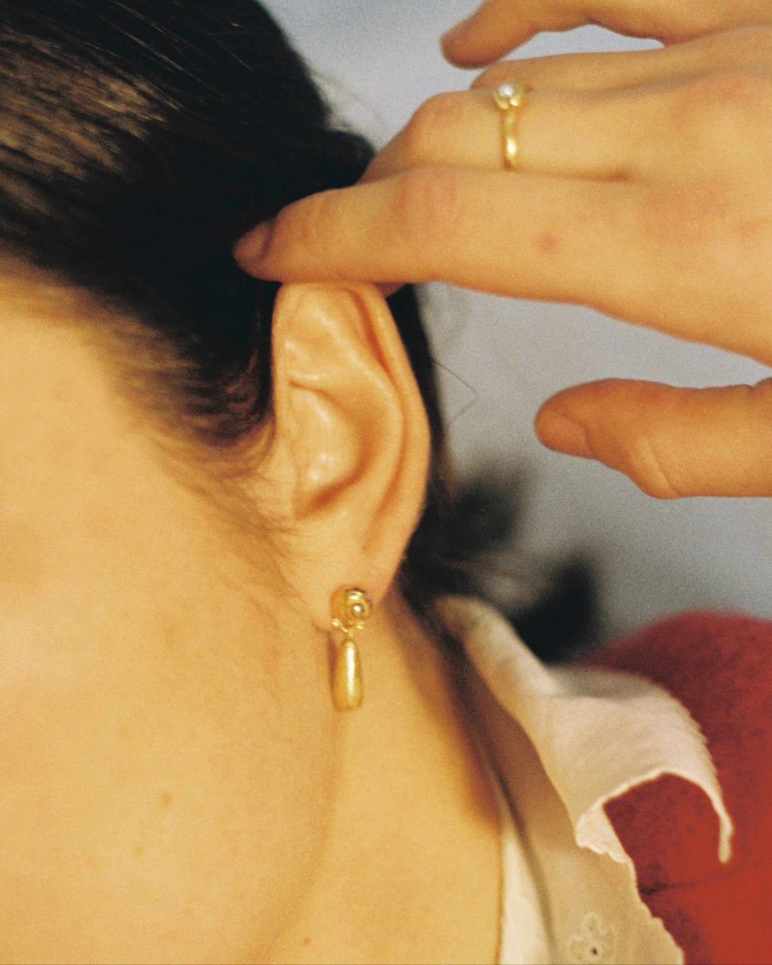 Pendientes bañados en oro alargados. Foto detalle con modelo.