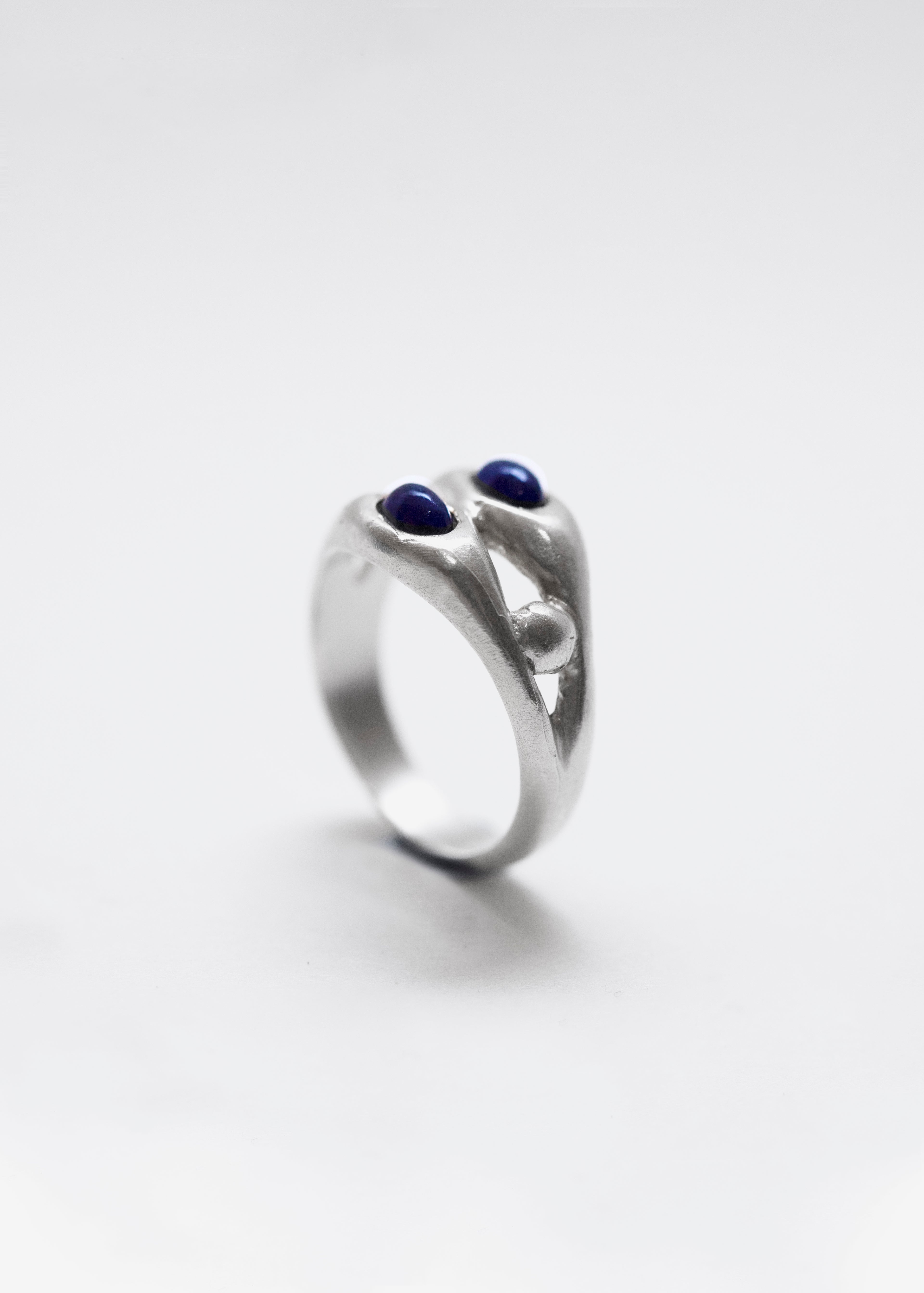Anillo artesanal con granate azul clavado en plata. Foto detalle producto. 