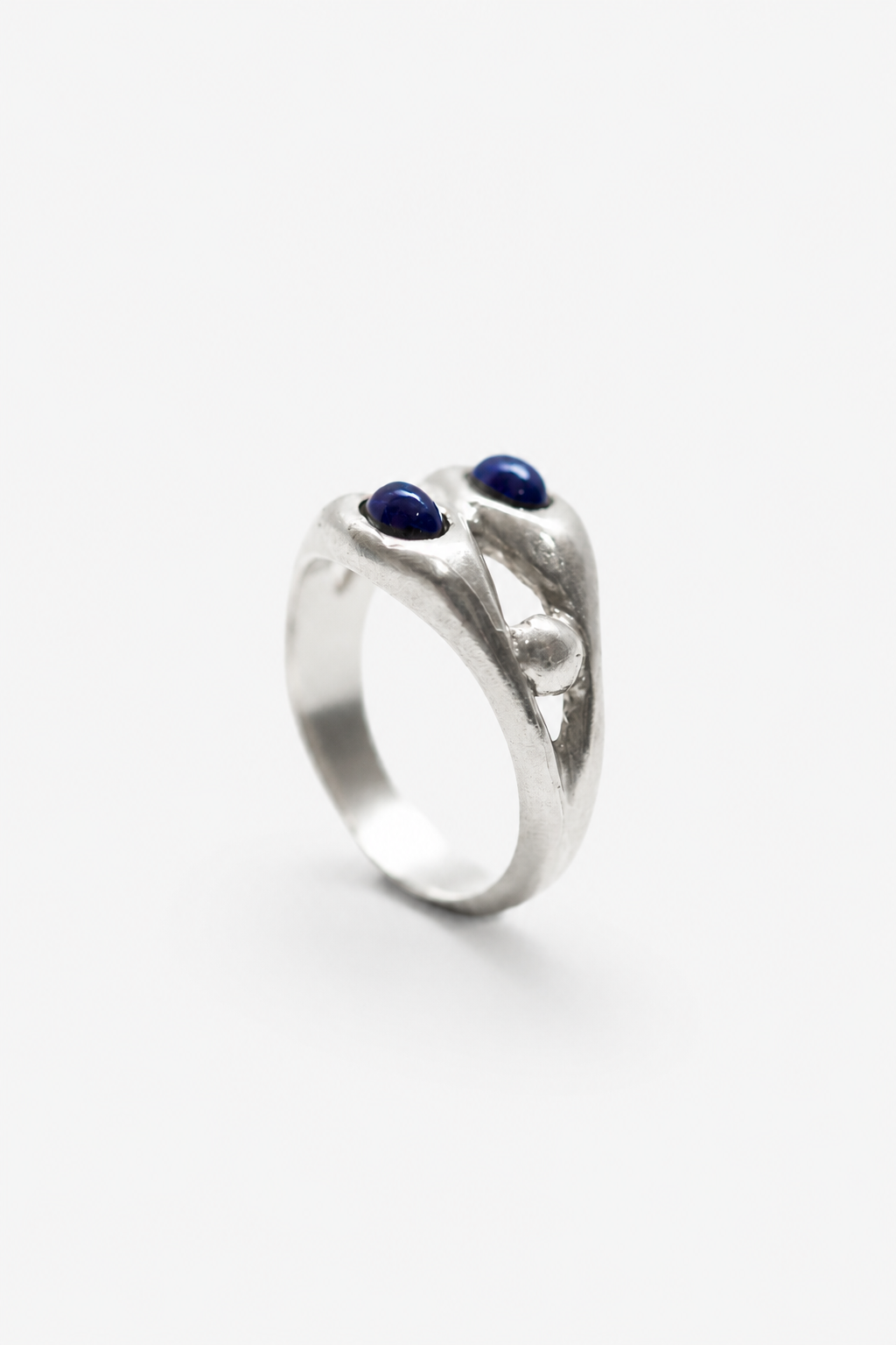 Anillo artesanal con granate azul clavado en plata. Foto detalle producto. 
