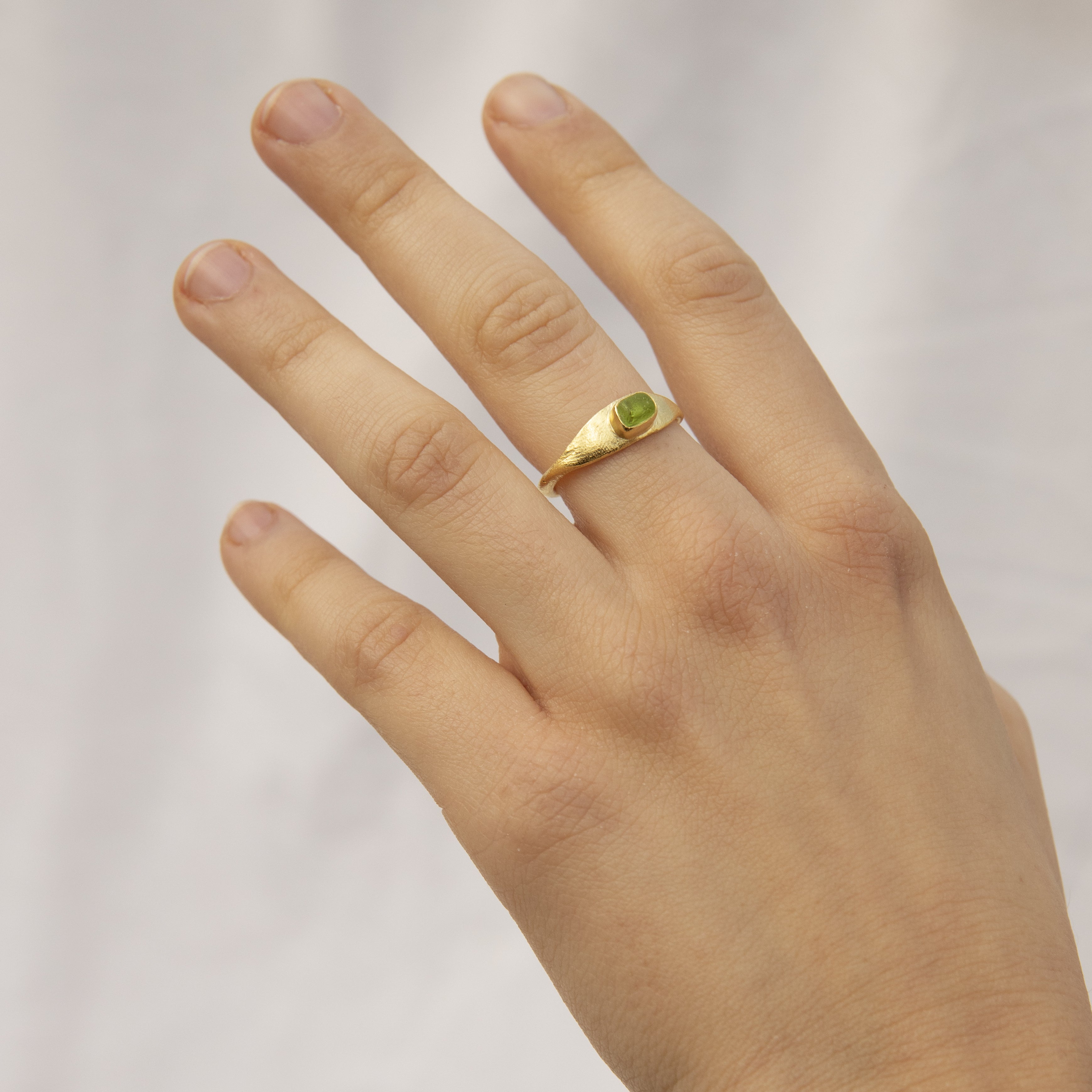 Anillo hecho a mano con cristal verde claro clavado, bañado en oro. Foto modelo. 