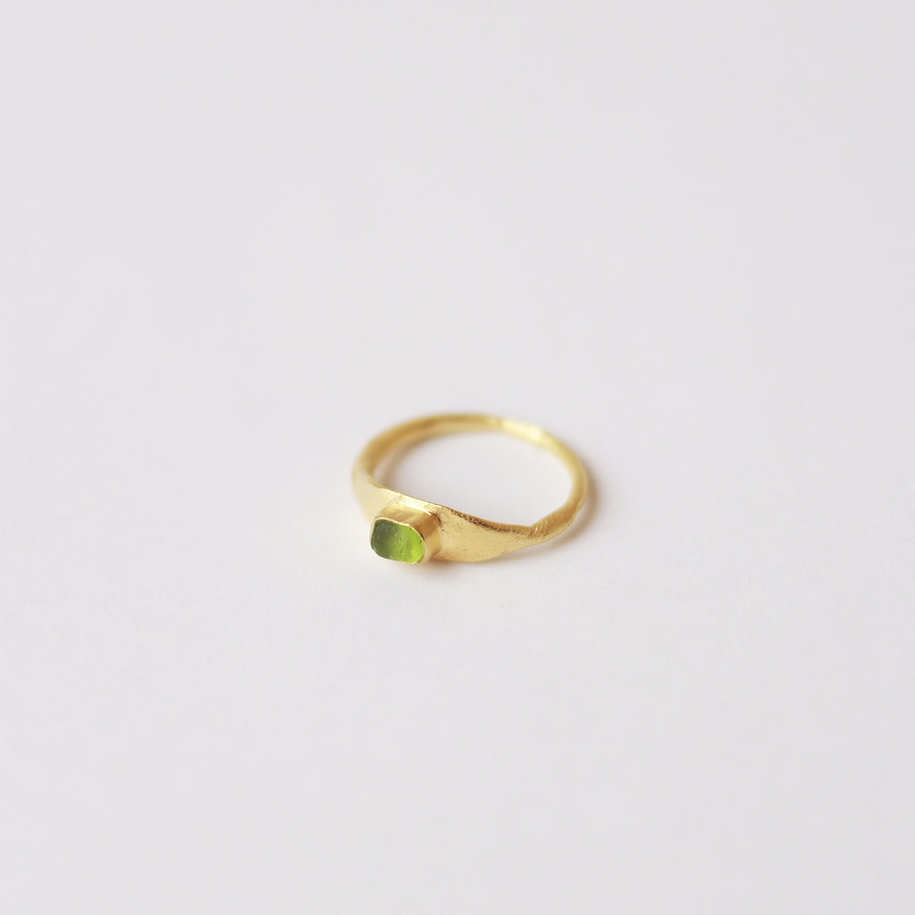 Anillo hecho a mano con cristal verde claro clavado, bañado en oro. Foto detalle producto. 