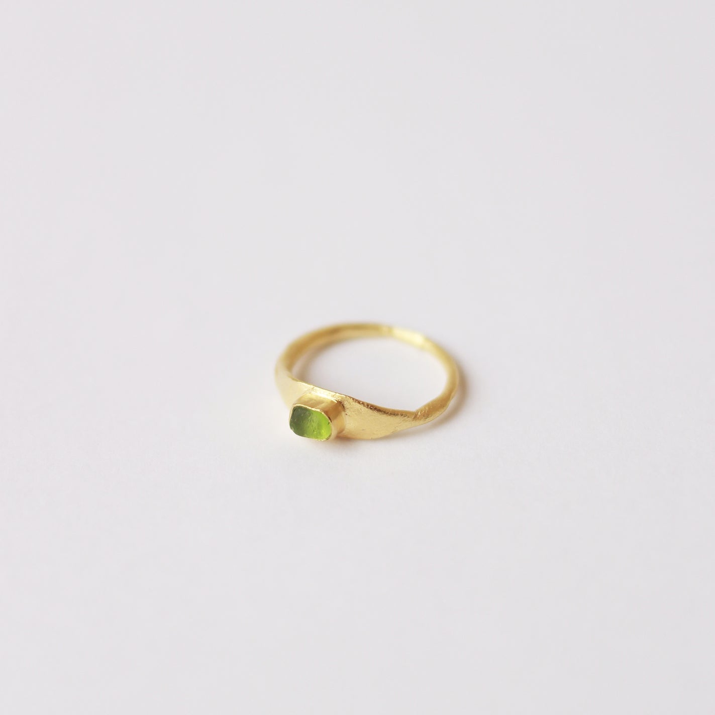 Anillo hecho a mano con cristal verde claro clavado, bañado en oro. Foto detalle producto. 