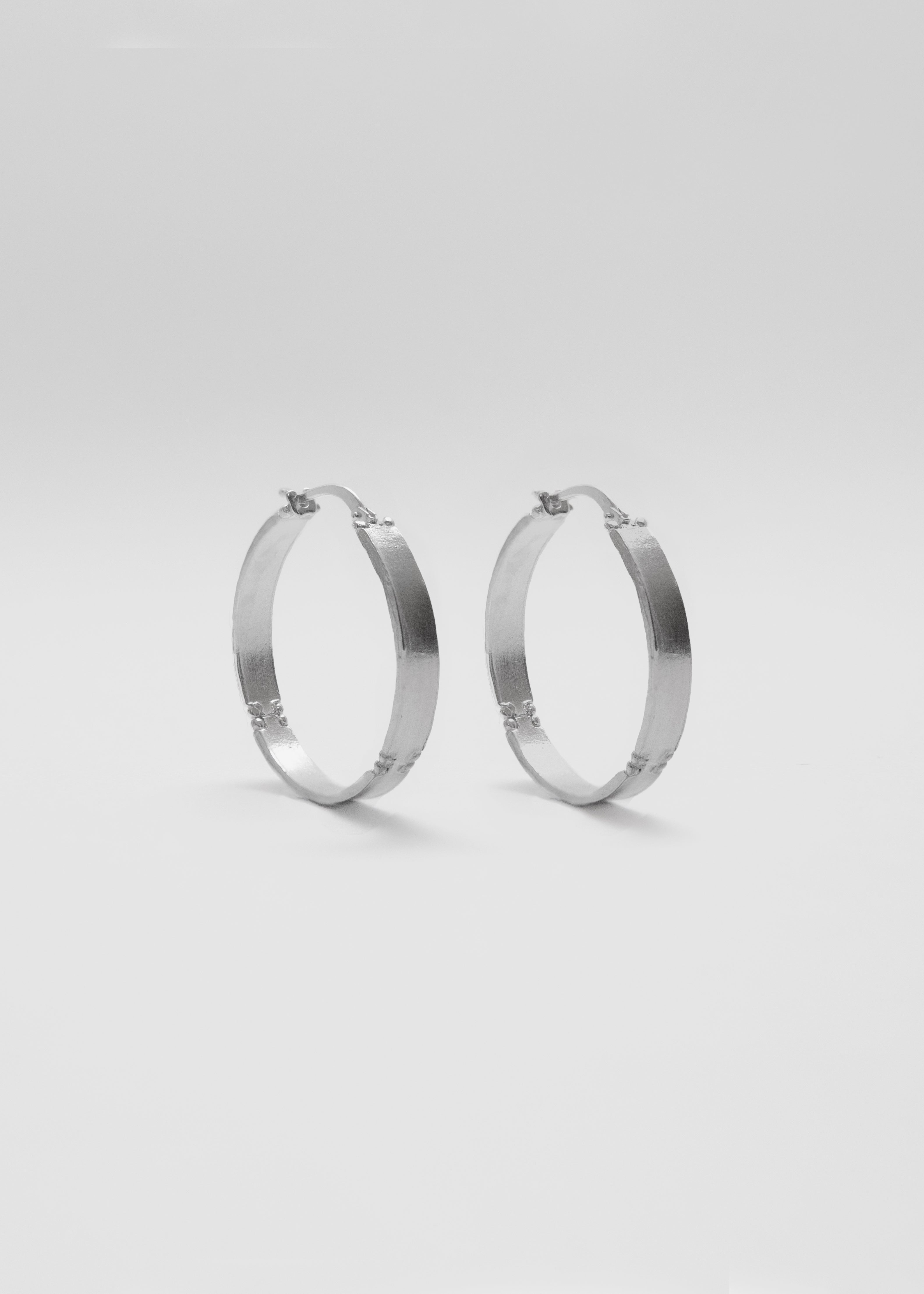 Pendientes en forma de aro, hechos a mano, piezas planas, en plata. Foto detalle producto. 