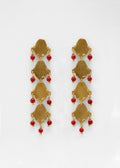 Pendientes largo hechos a mano con piedras rojas, bañados en oro. Foto detalle de producto. 