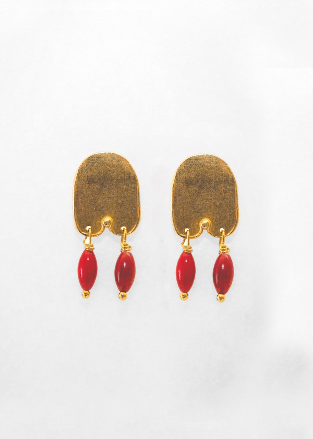 Pendientes hechos a mano con piedras rojas bañado en oro. Foto detalle de producto. 