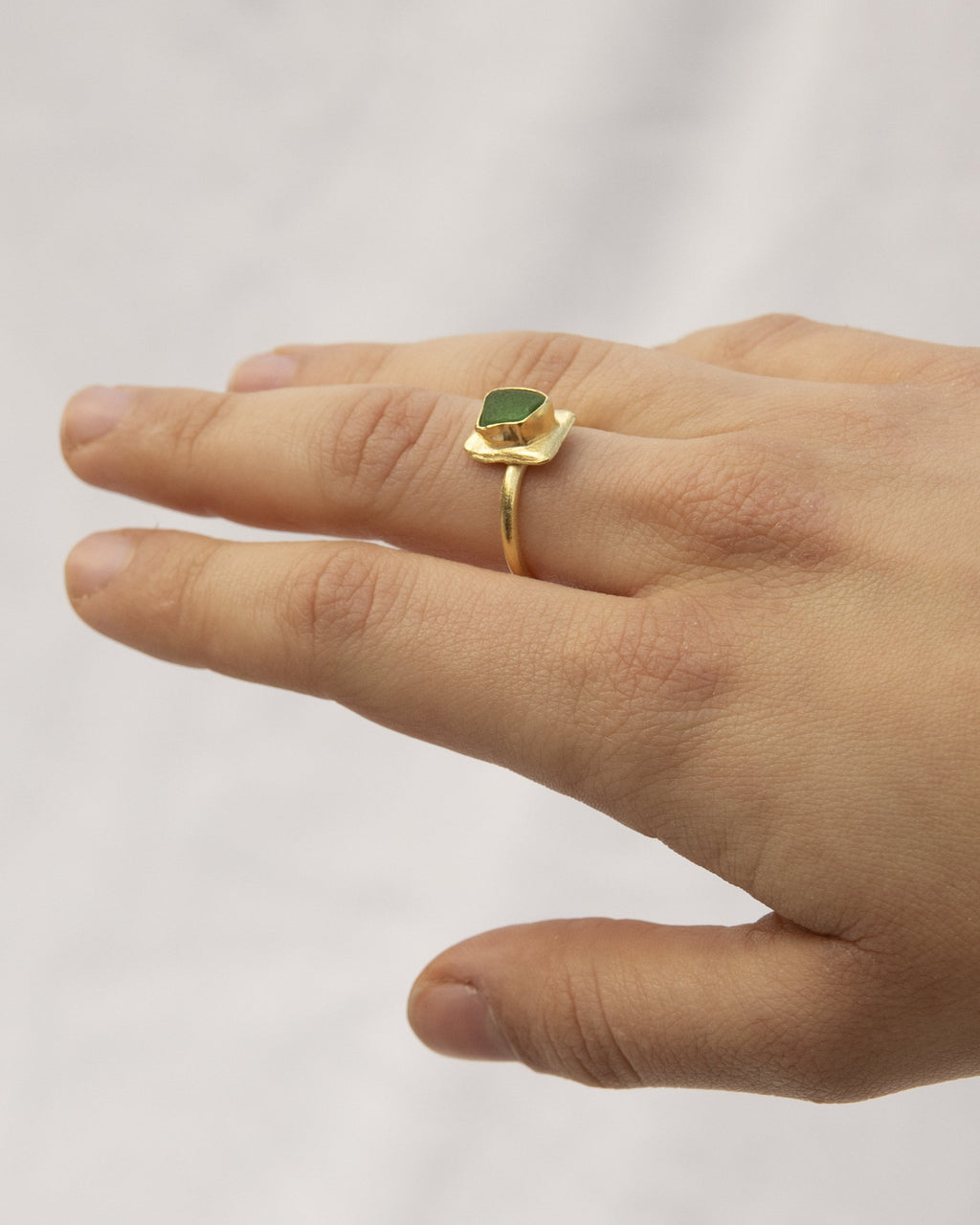 Anillo artesanal bañado en oro con cristal verde natural. Diseño escultural hecho a mano. Foto detalle modelo