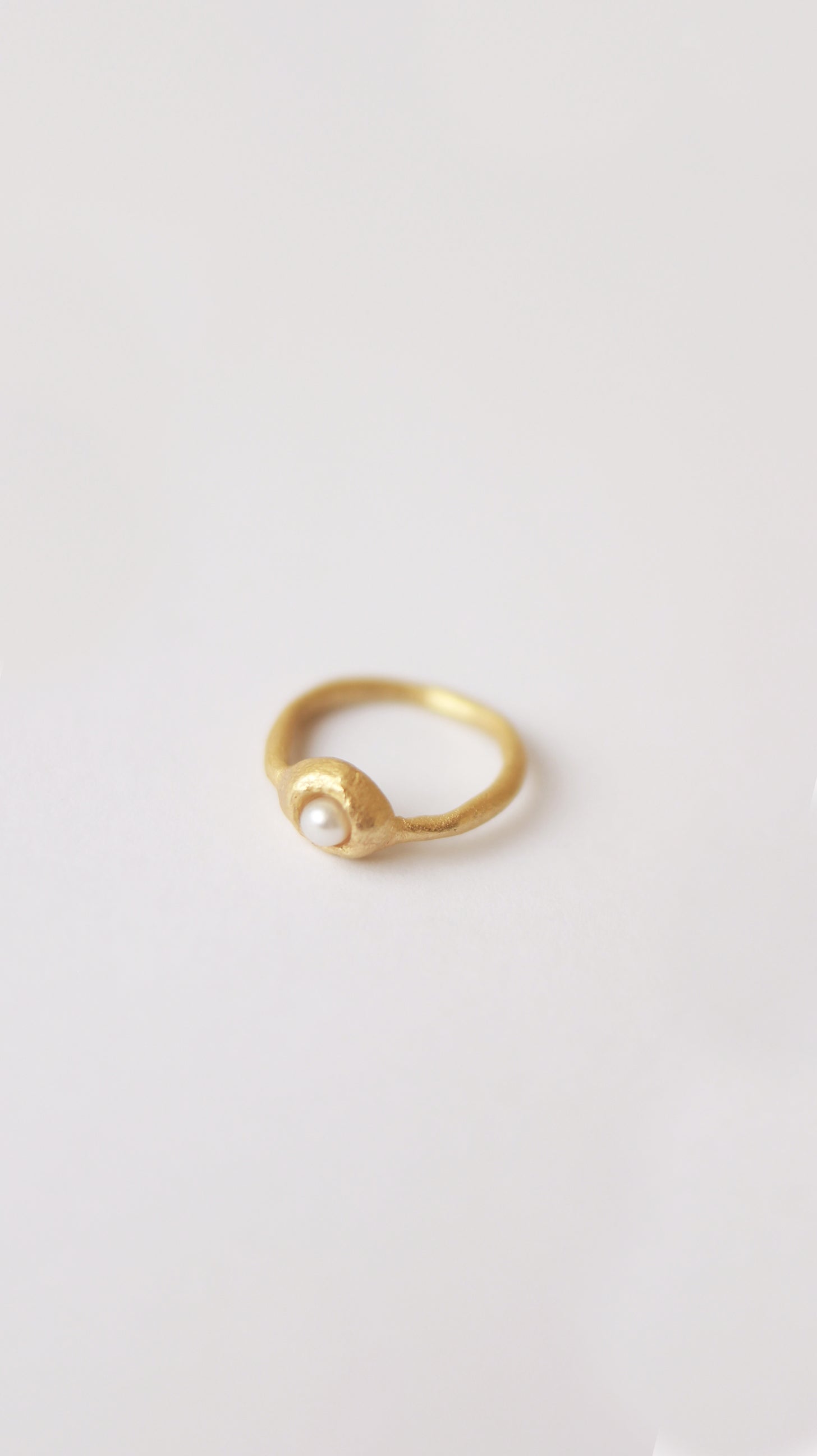 Anillo hecho a mano con perla cultivada bañado en oro. Foto detalle.