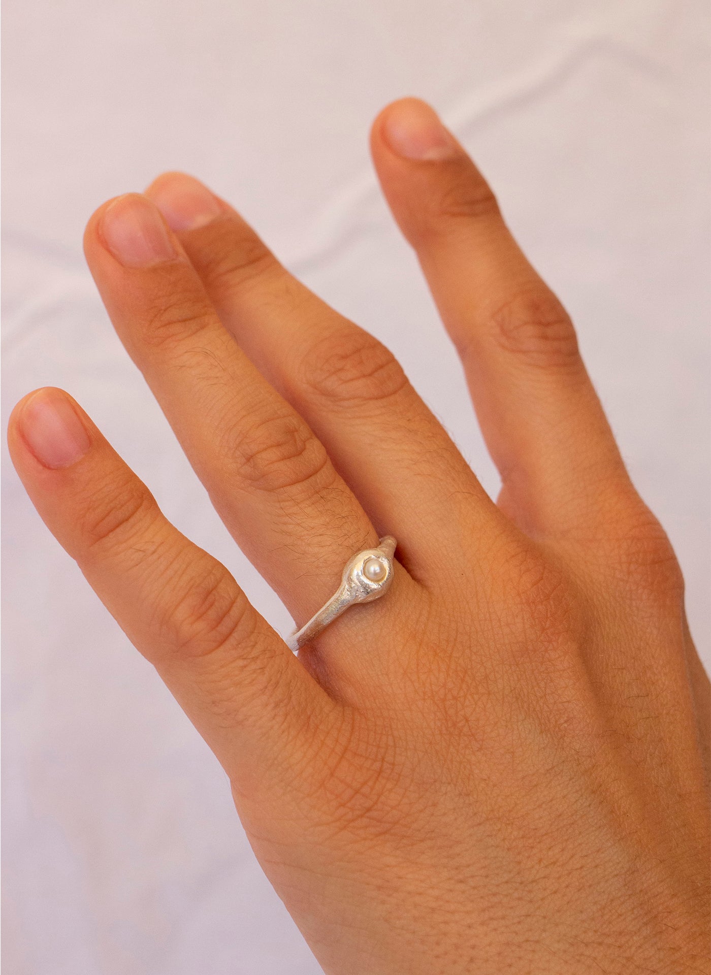 Anillo hecho a mano con perla cultivada en plata. Foto modelo.