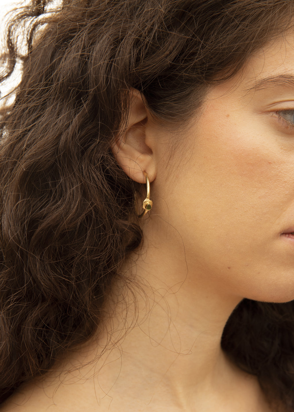 Pendientes artesanales en forma de aro con cristales verdes del mar mediterráneo, en oro. Foto detalle modelo.