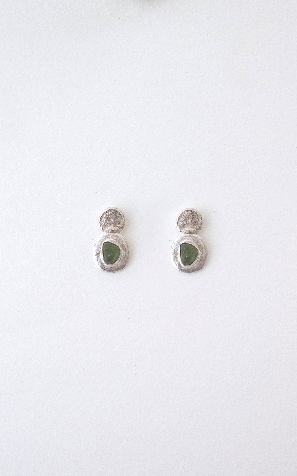 Pendientes artesanales con cristales verdes clavados y detalles en la parte superior, en plata. Foto detalle producto. 
