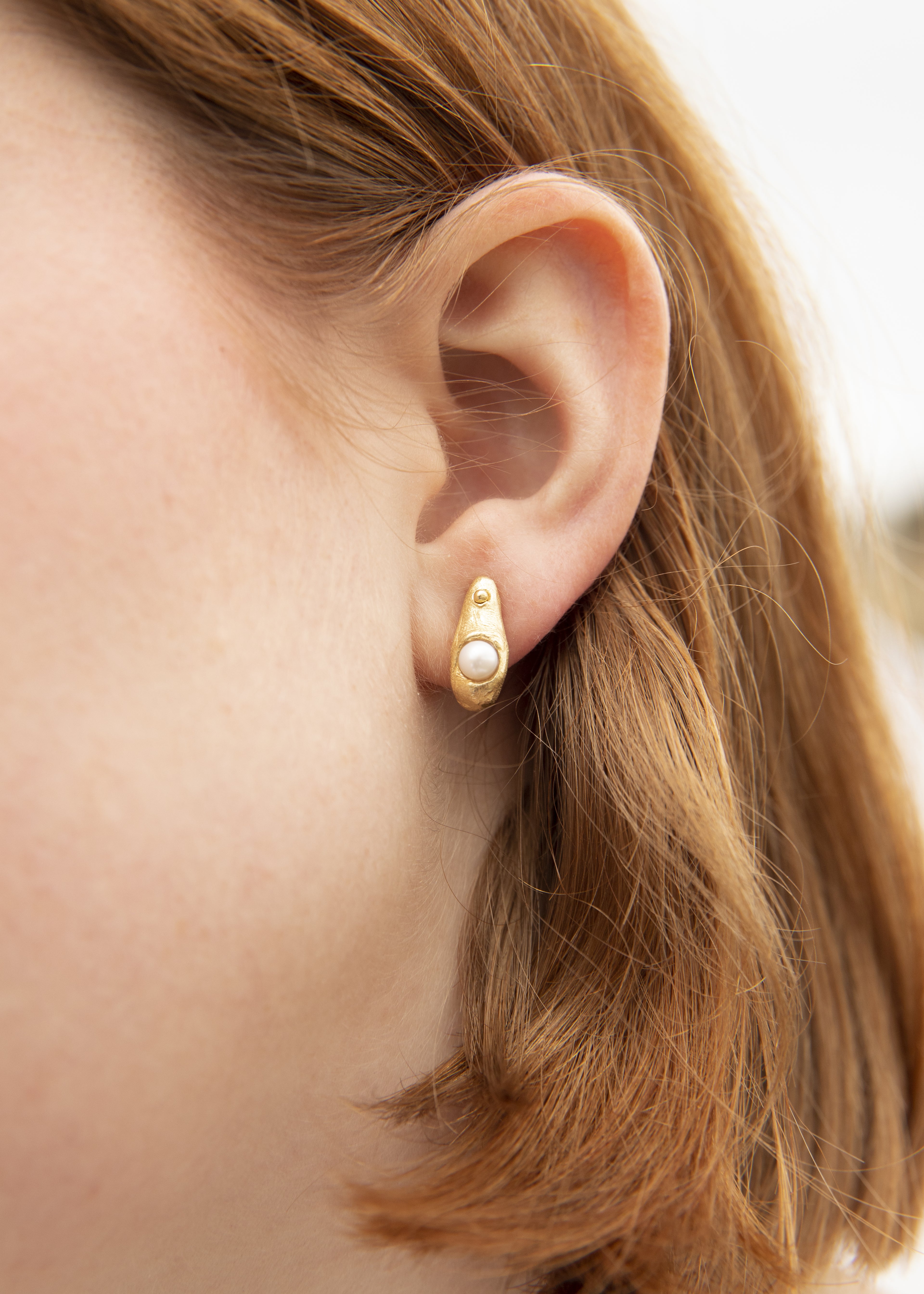 Pendientes artesanales en forma de gota con una perla cultivada incrustada, bañados en oro. Foto detalle modelo