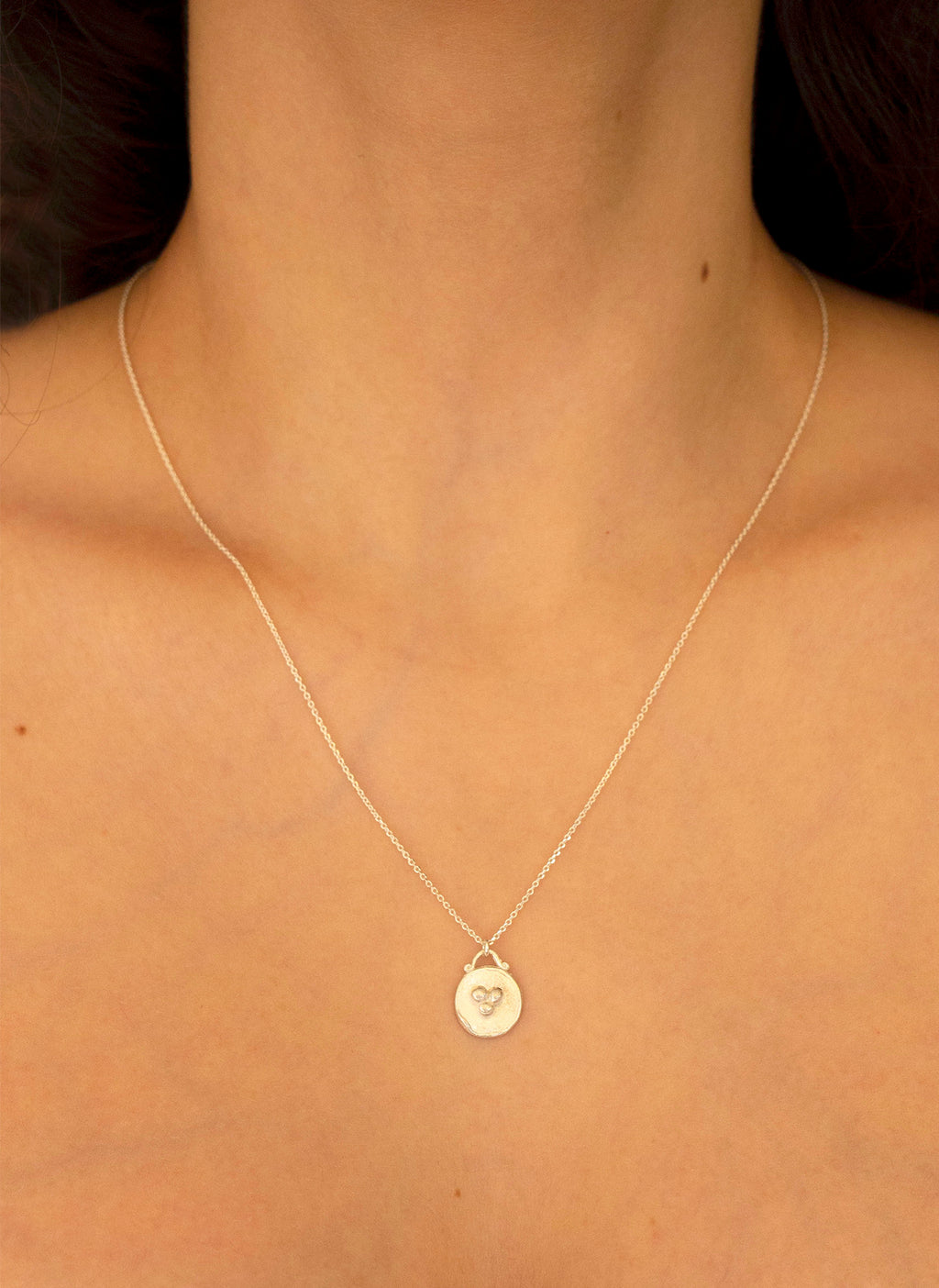 Colgante de plata de medalla. Foto detalle en modelo.