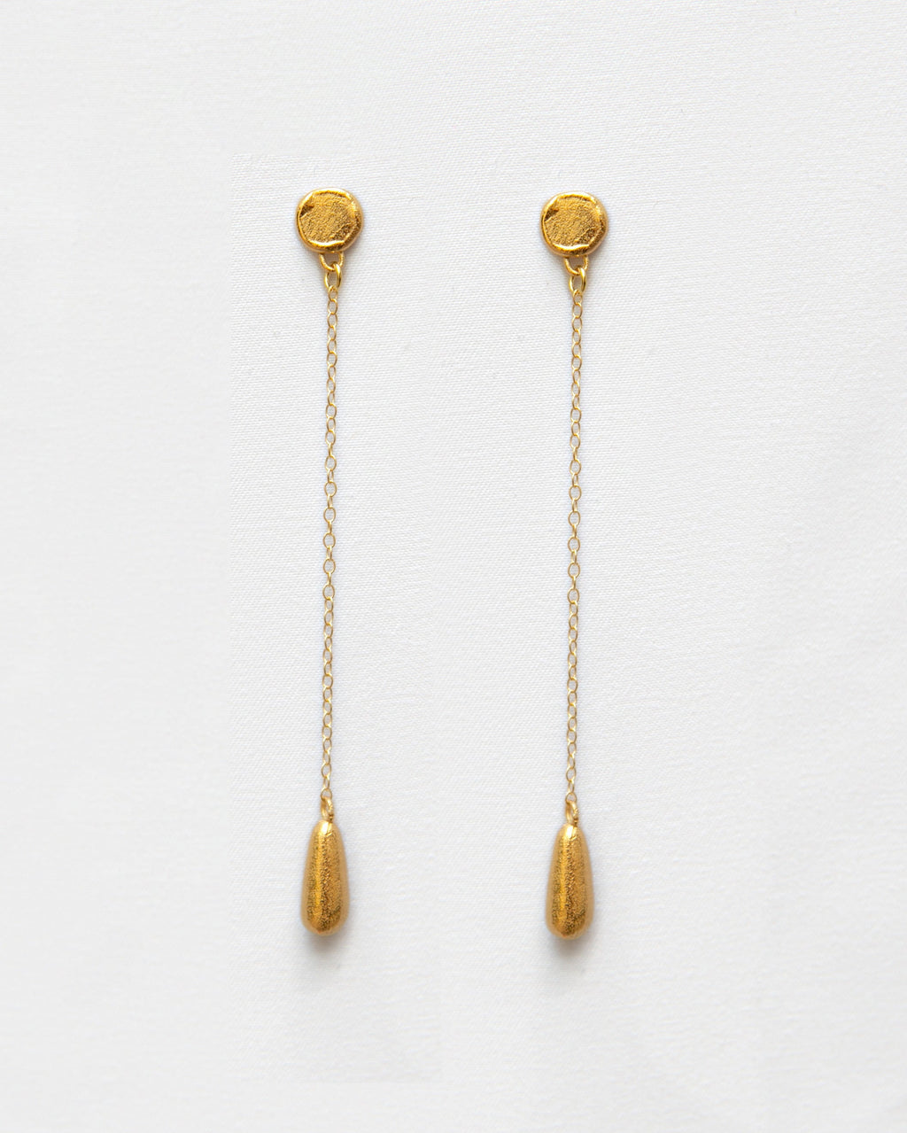 Pendientes bañados en oro en forma de lágrima con cadena. Foto detalle.