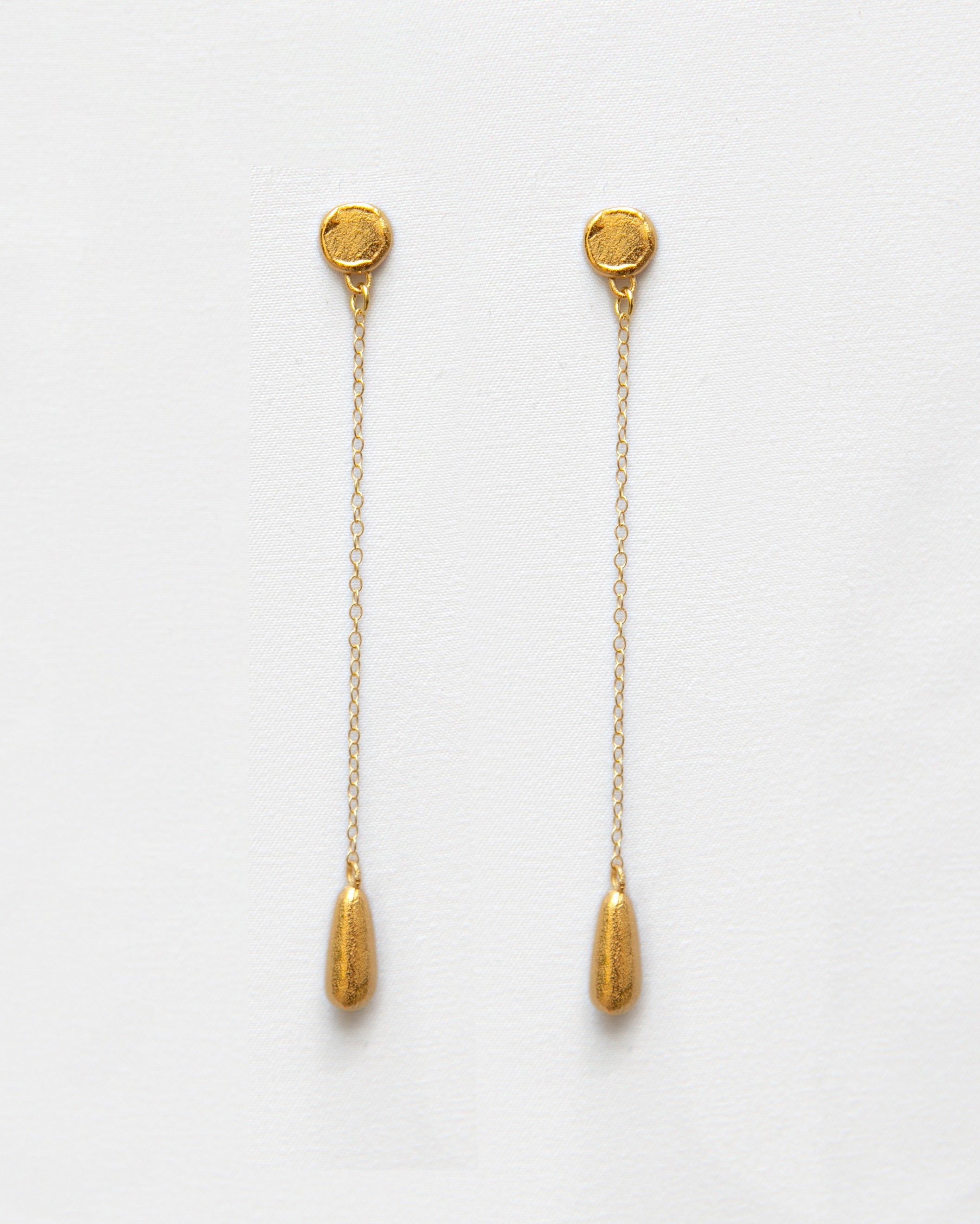 Pendientes bañados en oro en forma de lágrima con cadena. Foto detalle.