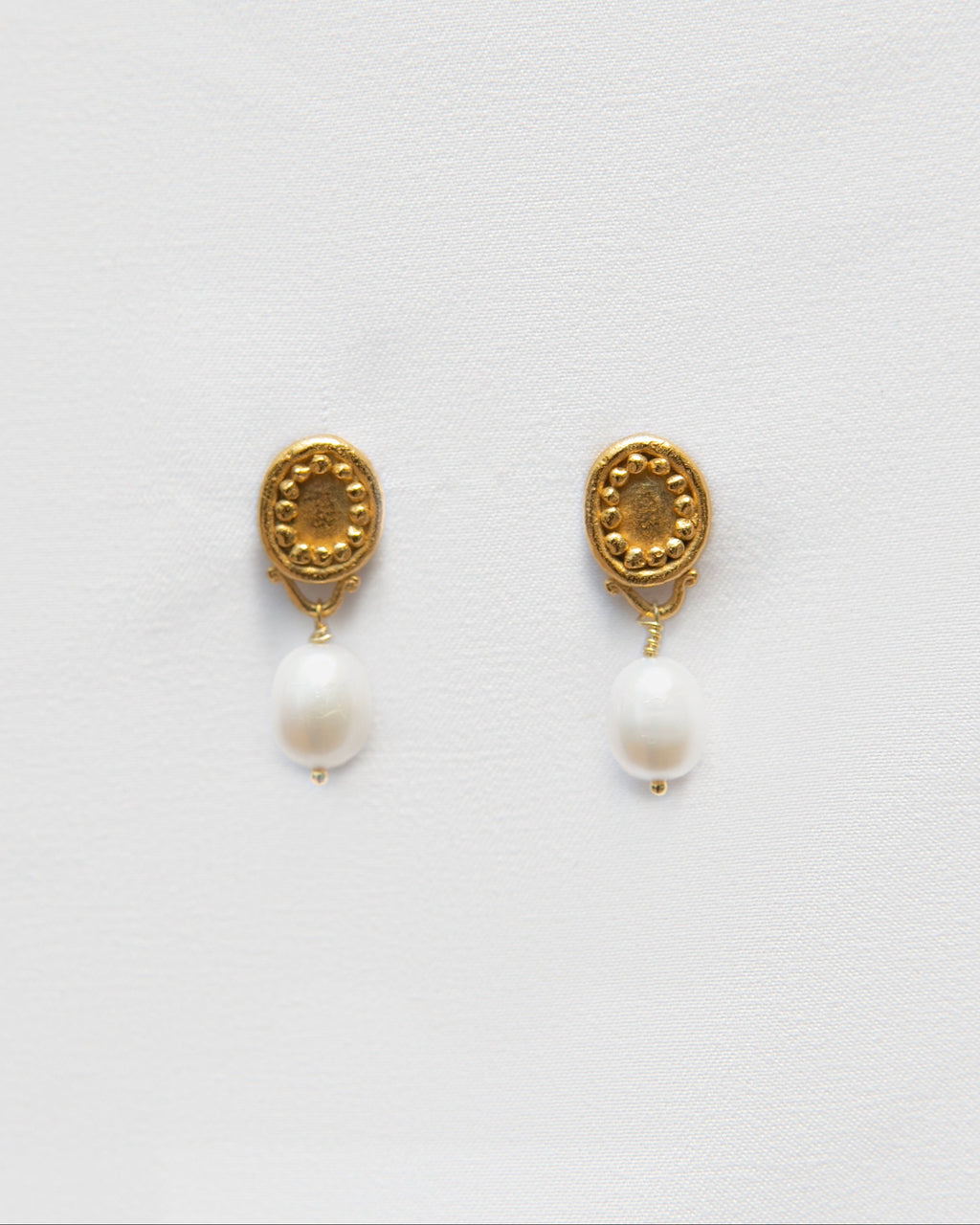 Pendientes bañados en oro de perlas cultivadas. foto detalle.