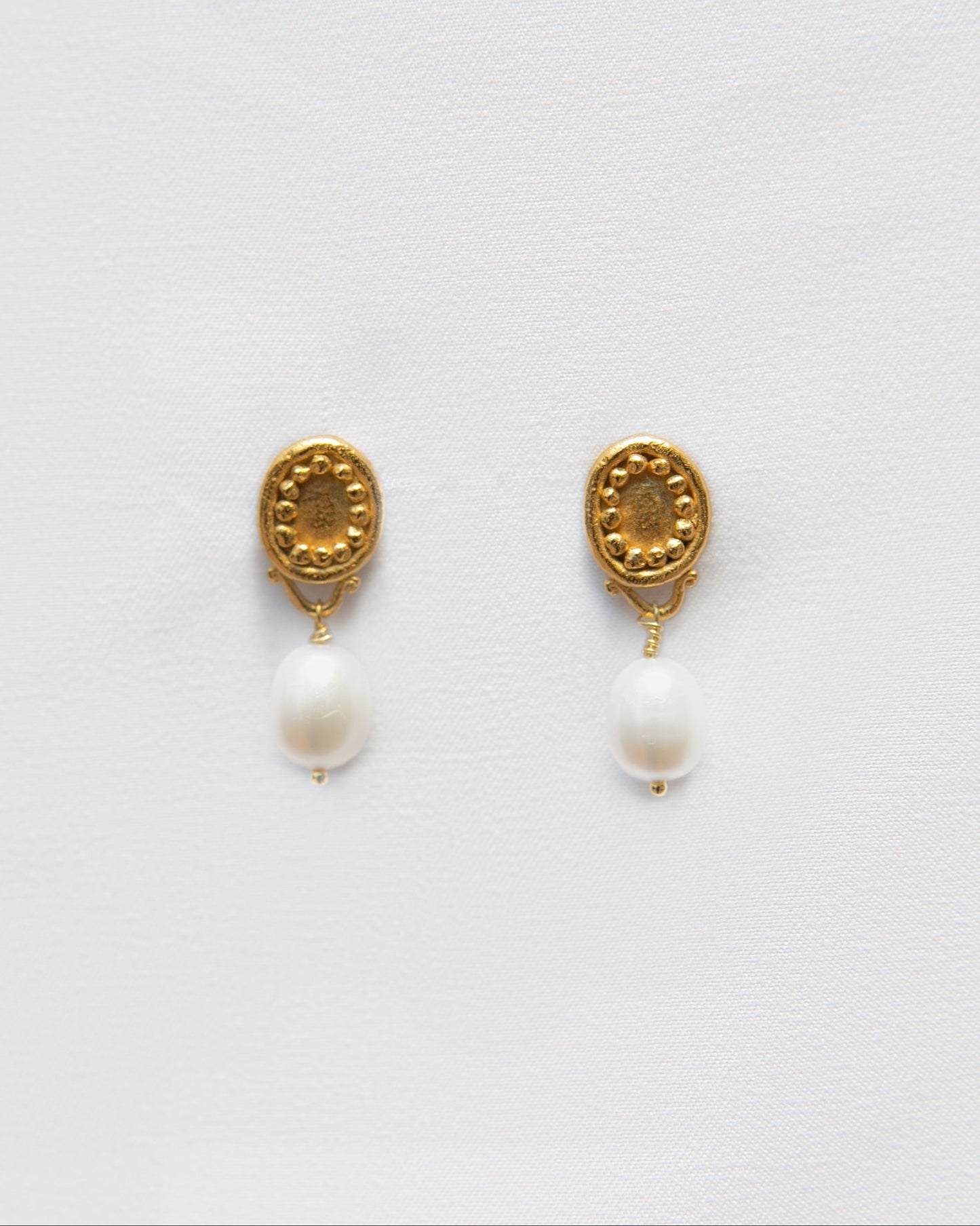 Pendientes bañados en oro de perlas cultivadas. foto detalle.