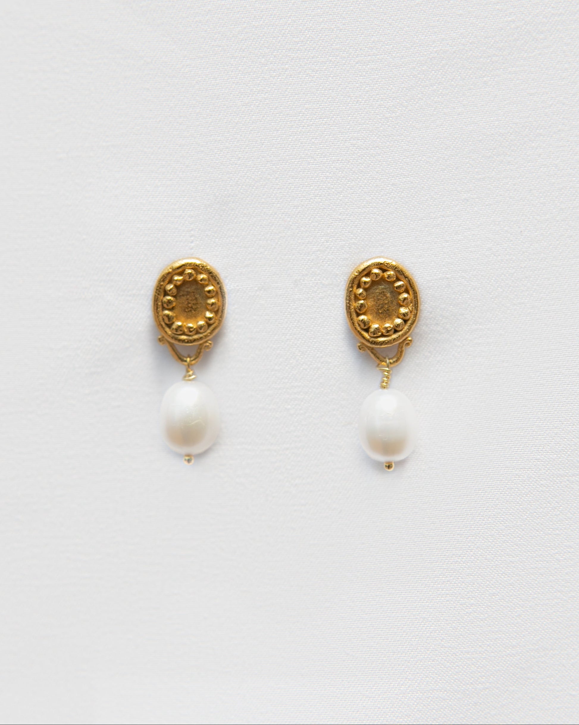 Pendientes bañados en oro de perlas cultivadas. foto detalle.